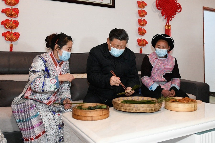 2021年2月3日下午，習(xí)近平在貴州畢節(jié)市黔西縣新仁苗族鄉(xiāng)化屋村苗族村民趙玉學(xué)家，同一家人邊聊家常邊制作當(dāng)?shù)貍鹘y(tǒng)節(jié)日食品黃粑。新華社記者 李學(xué)仁 攝